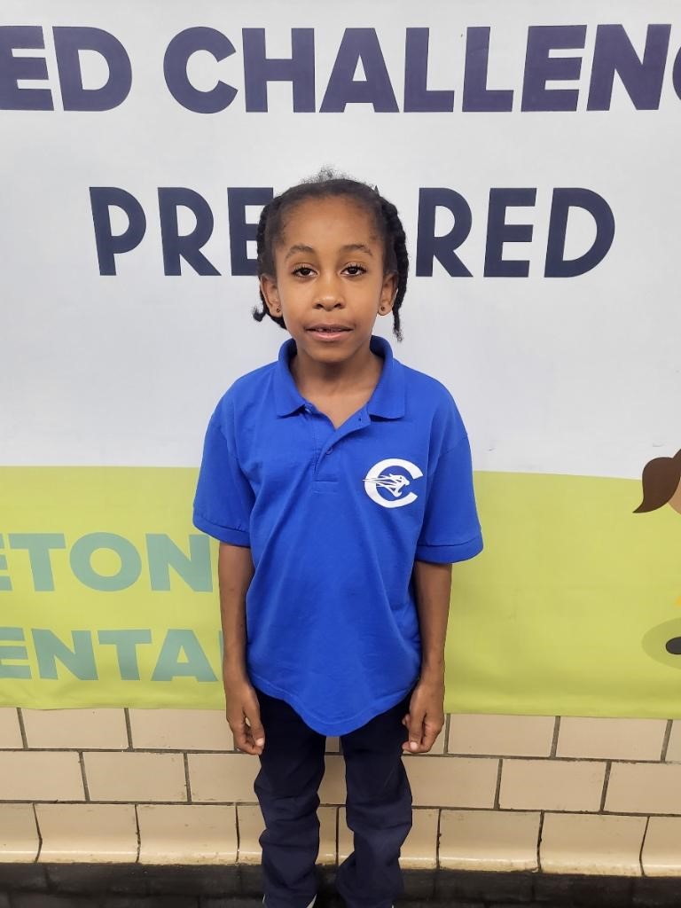 A child standing in front of a signDescription automatically generated